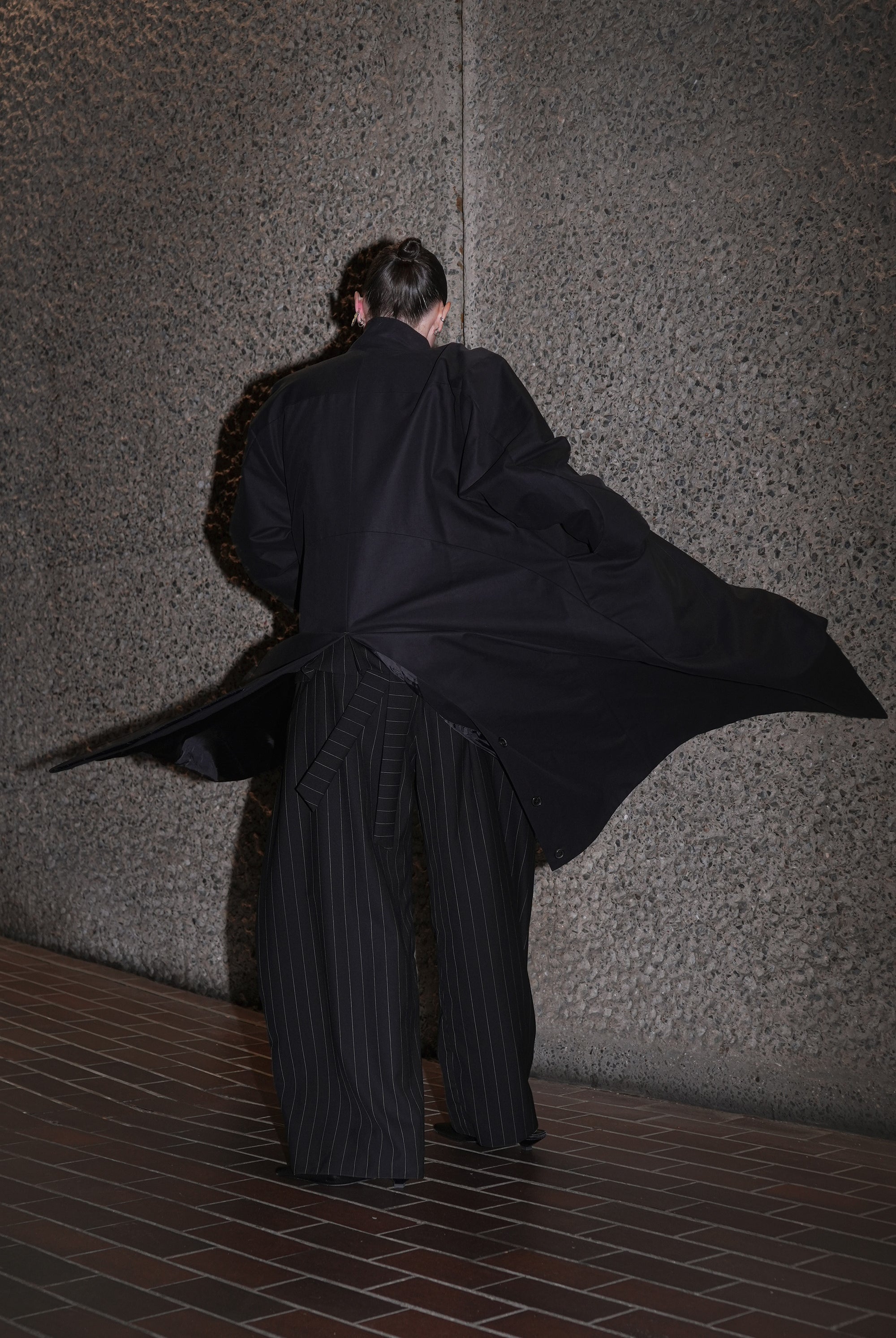 MODEL WEARING MOMA HILO HILDA COAT MADE FROM BLACK DEADSTOCK FABRIC