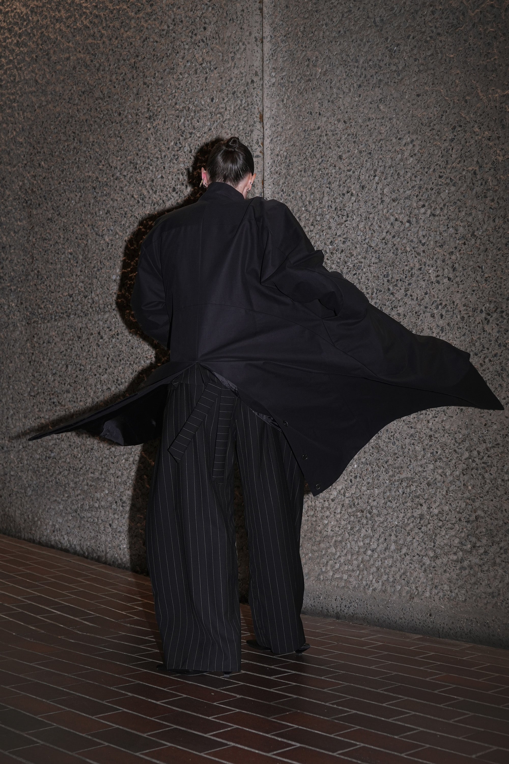 MODEL WEARING MOMA HILO HILDA COAT MADE FROM BLACK DEADSTOCK FABRIC