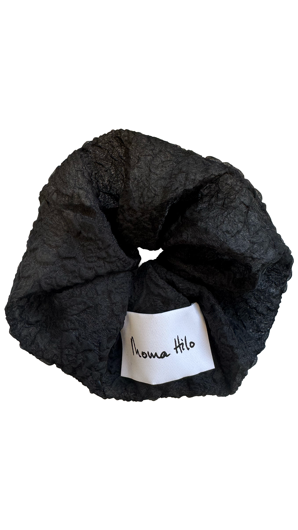 Black textured scrunchie with a white label on a white background
