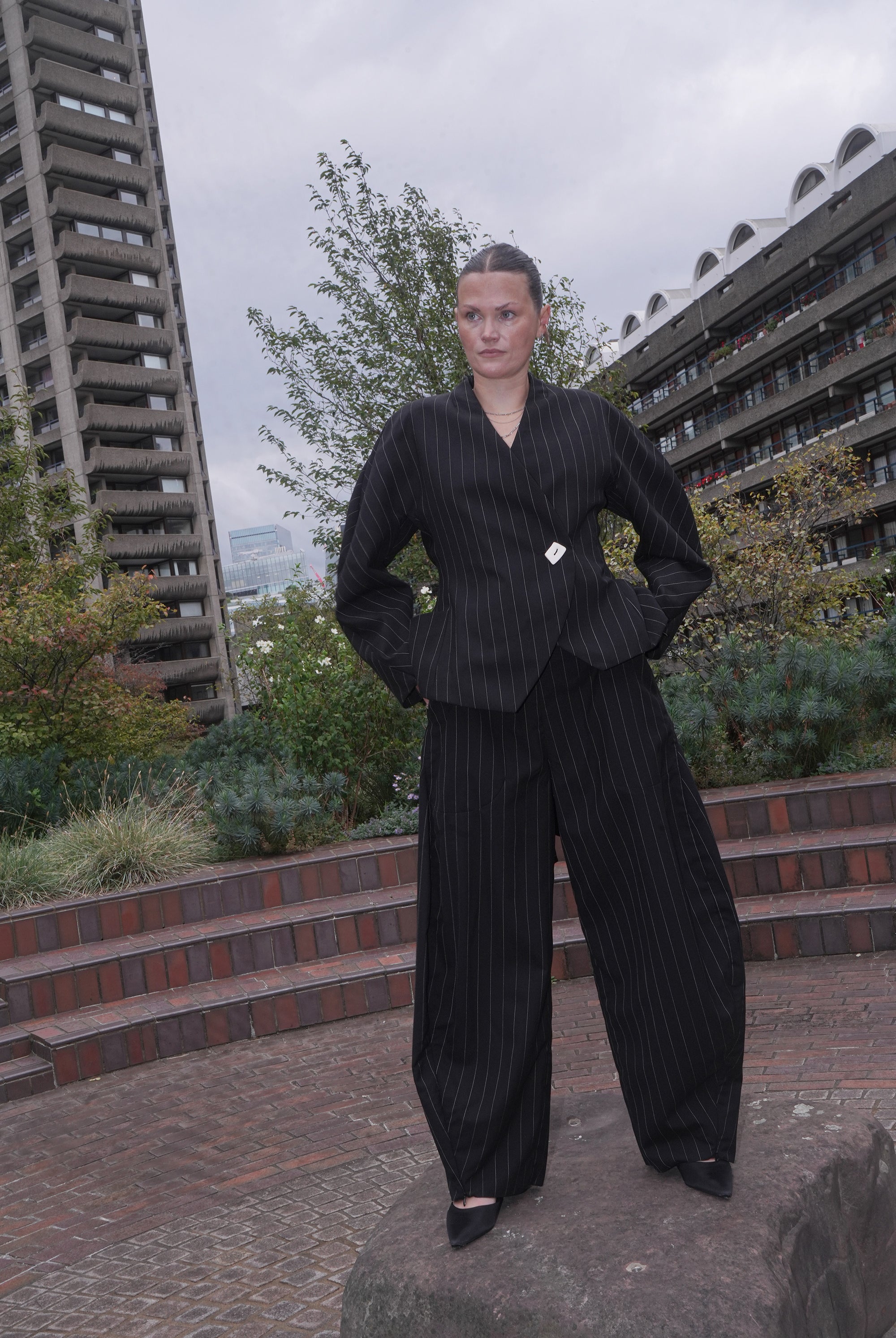 MODEL WEARING BLACK PINSTRIPE SUIT SET DALE TROUSERS AND MARGARET BLAZER