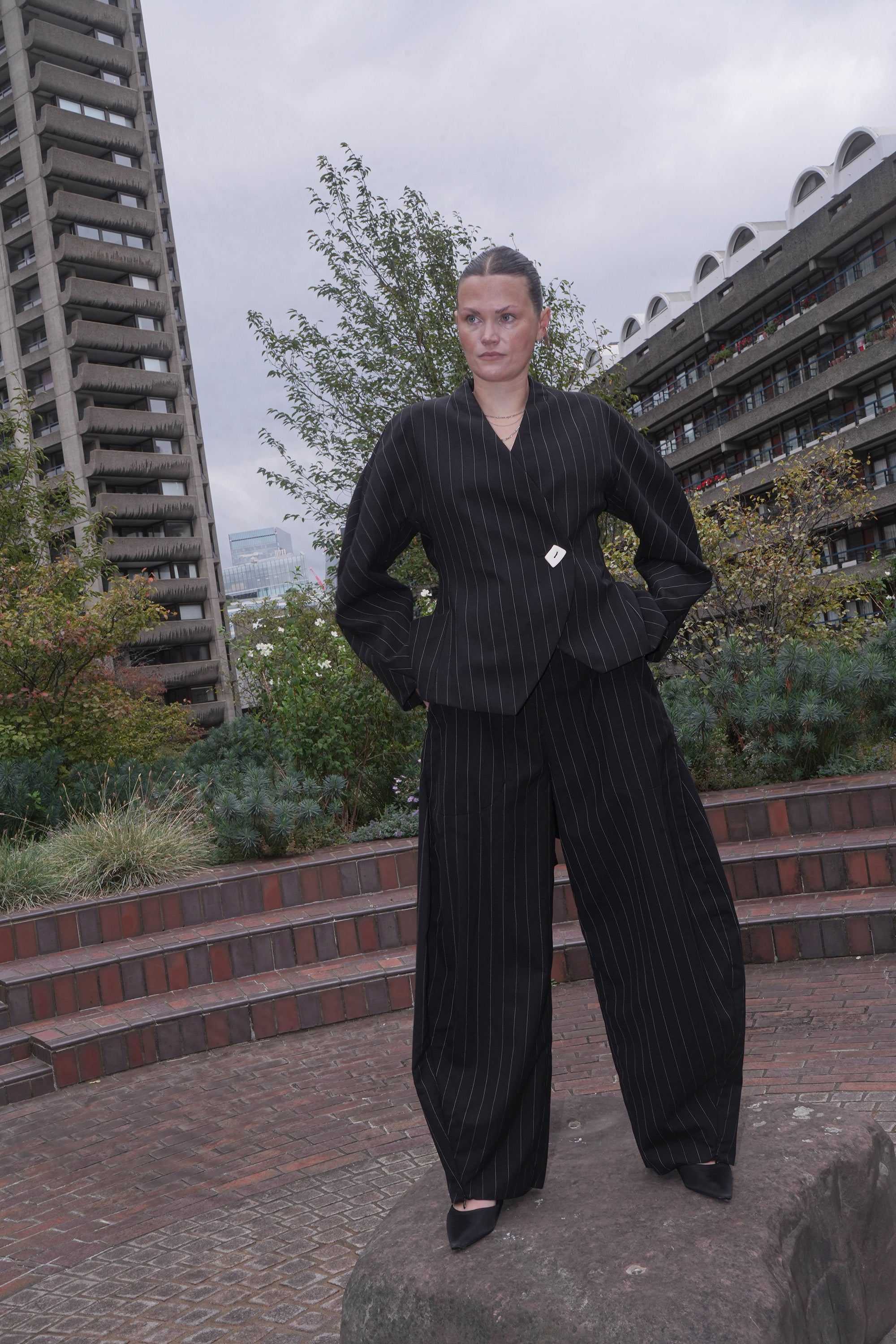 MODEL WEARING BLACK PINSTRIPE SUIT SET DALE TROUSERS AND MARGARET BLAZER