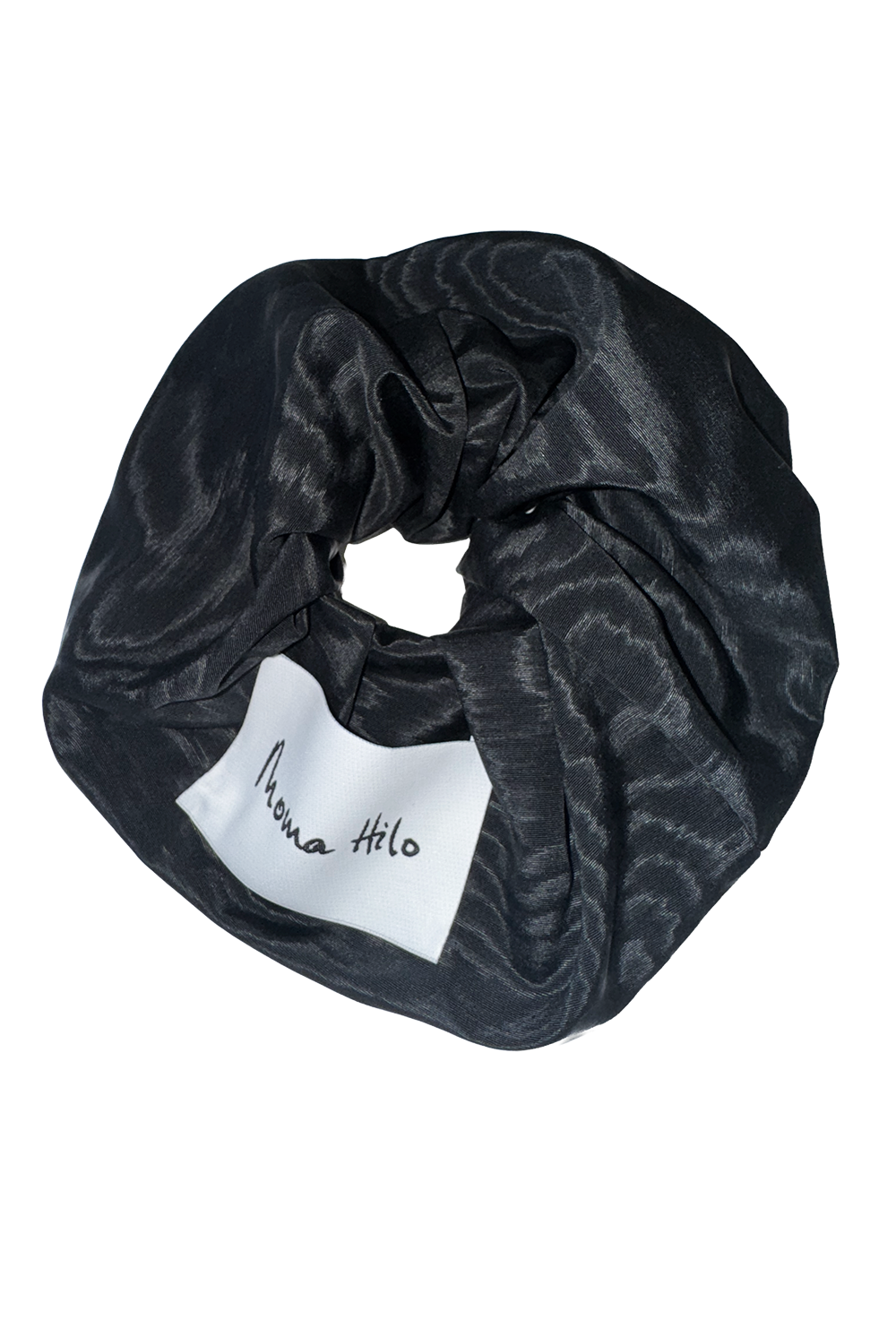 Black patterned scrunchie with a white label on a white background