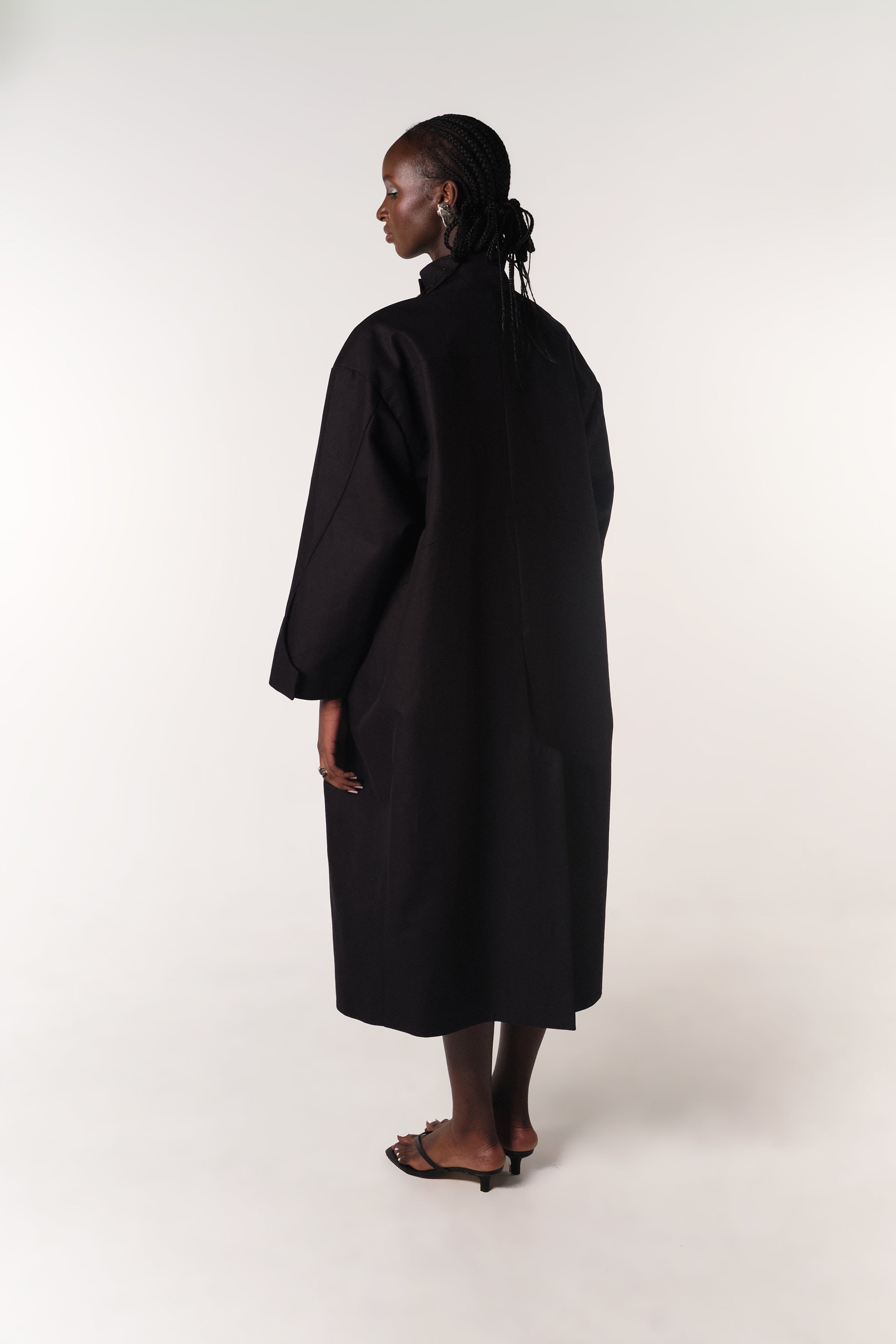 MODEL WEARING BLACK DEADSTOCK COTTON HILDA COAT SHOWING BACK DETAILS
