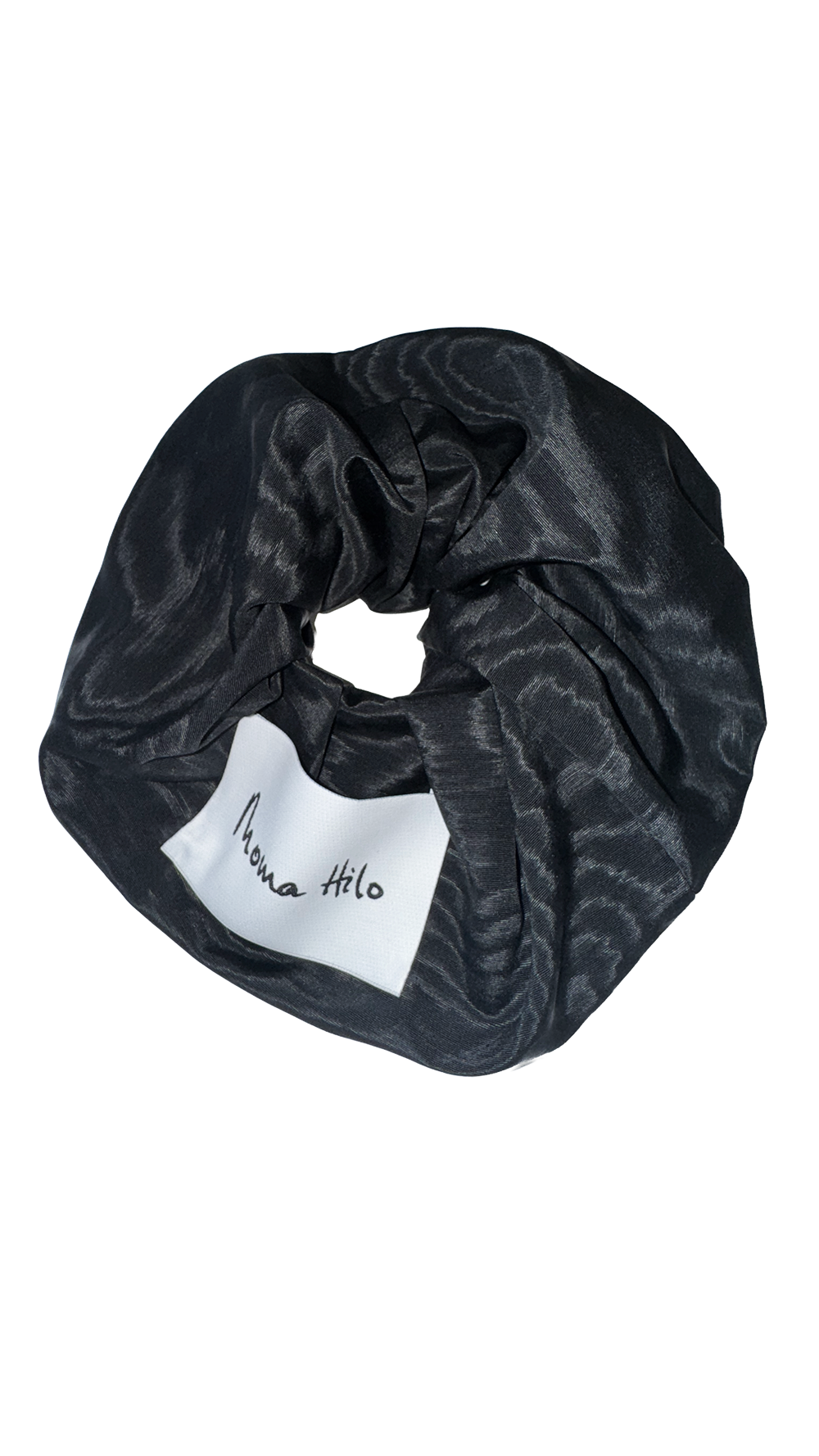 Black patterned scrunchie with a white label on a white background