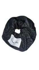 Black patterned scrunchie with a white label on a white background